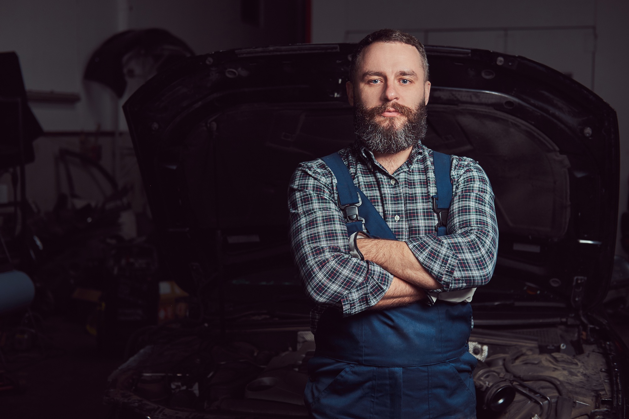 Bearded expert mechanic dressed in a uniform