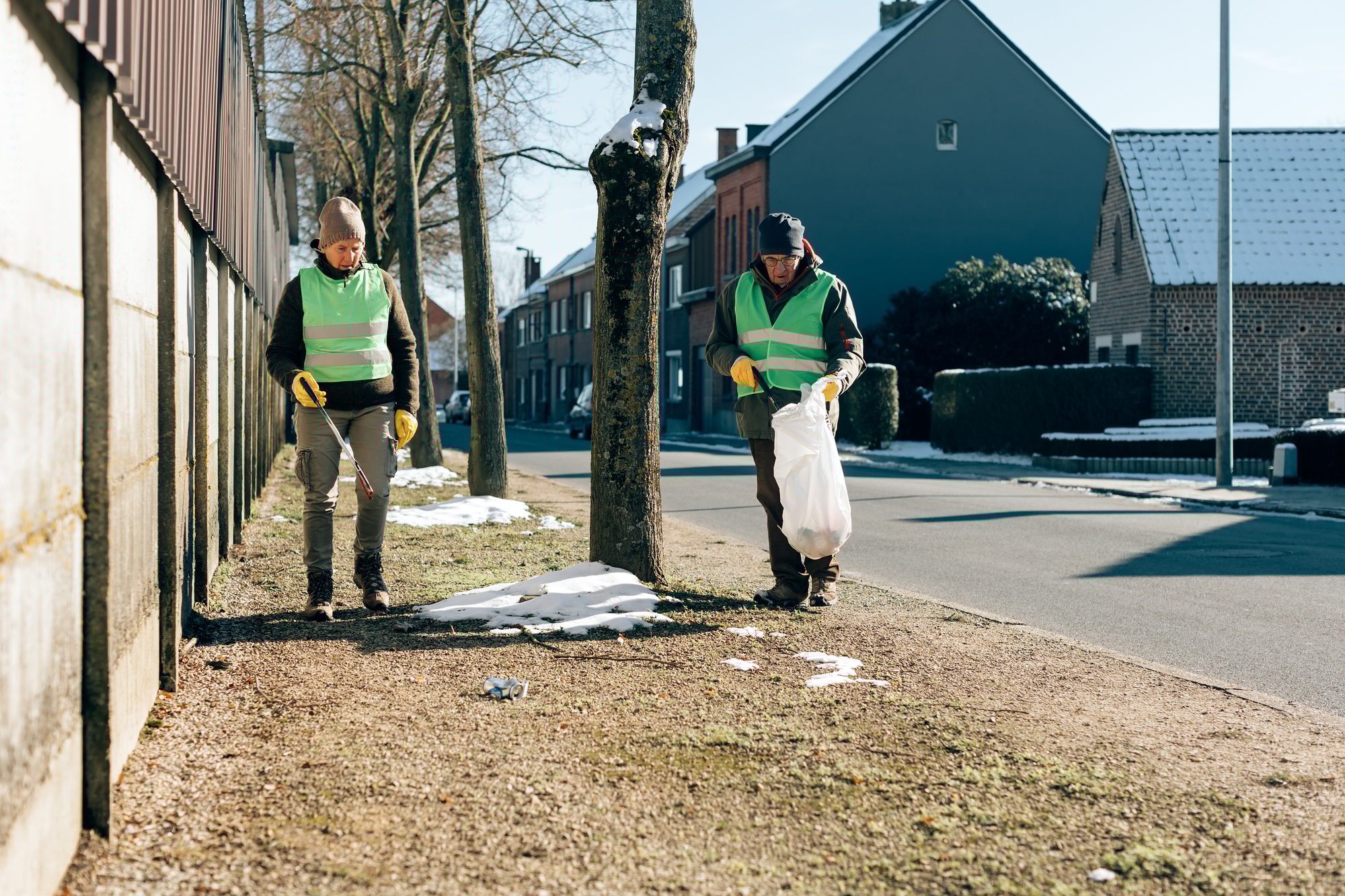 Senior volunteers picking up garbage outdoor in the city - Focus on faces